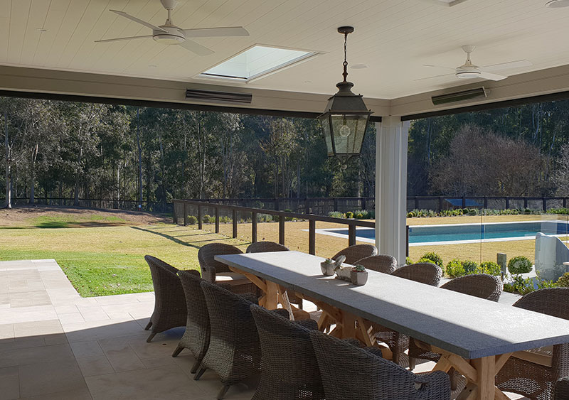 Patio with long table and chairs featuring folded a patio blinds